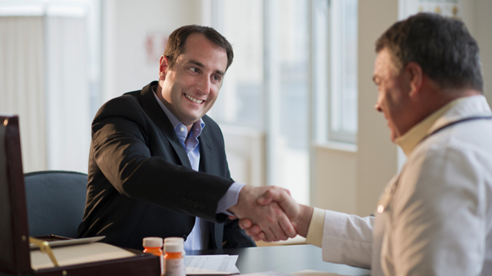 Industry executive shaking hands with doctor.