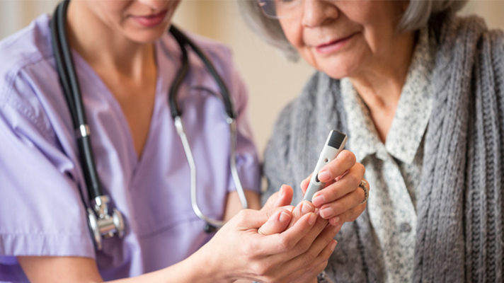 Skilled nurse caring for elderly woman.