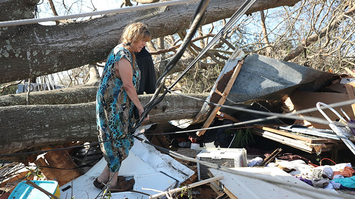 Kathy Coy stands among what is left of her home after Hurricane Michael destroyed it.