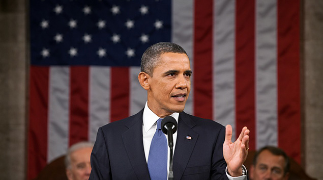 President Obama speaks in front of a large flag