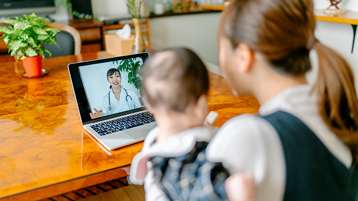 Woman with baby attending telehealth appointment