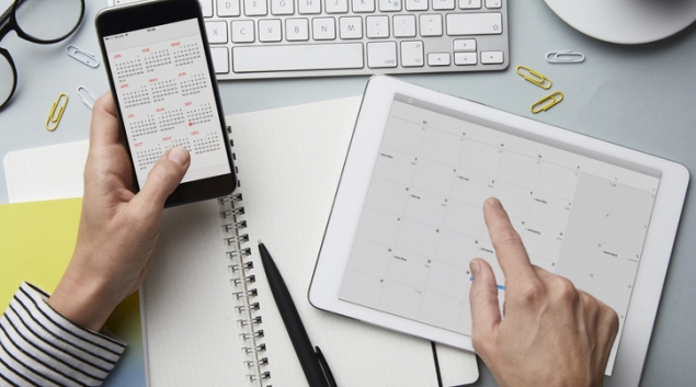 Person looking at calendar on tablet and smartphone