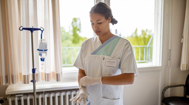 Medical worker putting on gloves