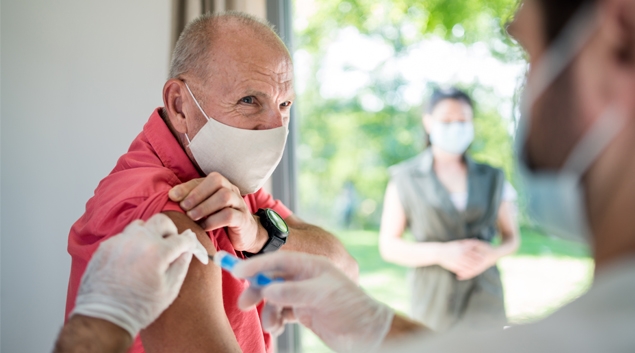 Patient in mask receiving vaccine