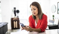 Person at table with smartphone