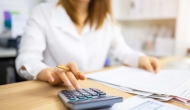 Person using calculator. Photo: Kiyoshi Hijiki/Getty Images