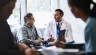 Doctor sits on couch with patient