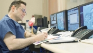 A doctor works in front of multiple computers.