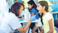 Doctor using a tongue depressor on young patient