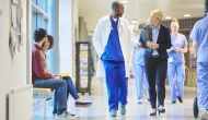 Physicians and others walking in hospital corridor