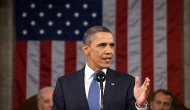 President Obama speaks in front of a large flag