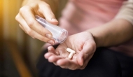 Hands dispensing pills from a bottle