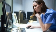 Healthcare professional looks at a computer screen