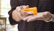 Person pouring pills into hand