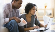 Couple with papers at a laptop