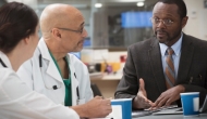 Three hospital executives meet at a table