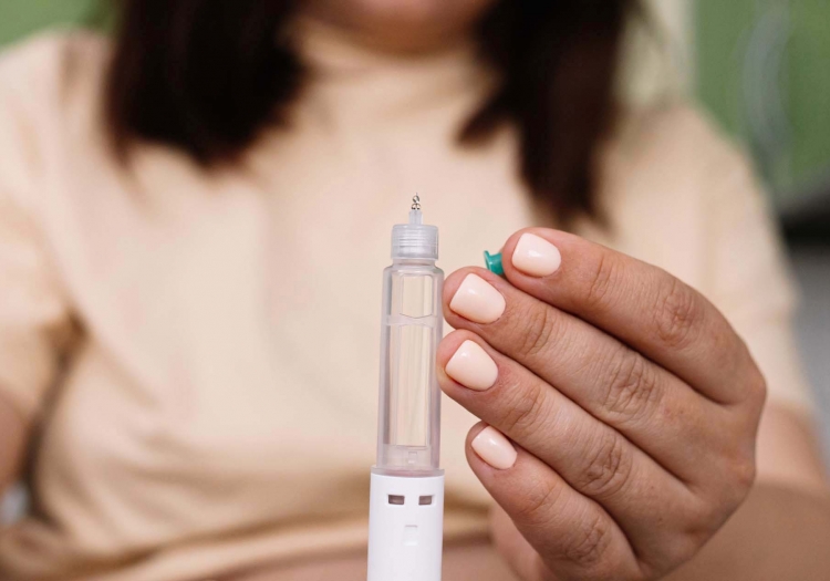 Person holds injection pen