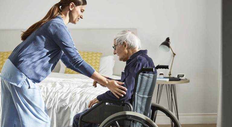 Clinician helping person in wheelchair