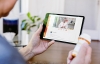 Person with pill bottle talking to doctor on a tablet