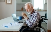 Person looking over medical forms with a calculator and laptop